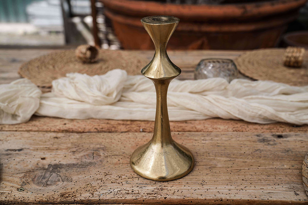 Kerzenständer in gold auf Holztisch.