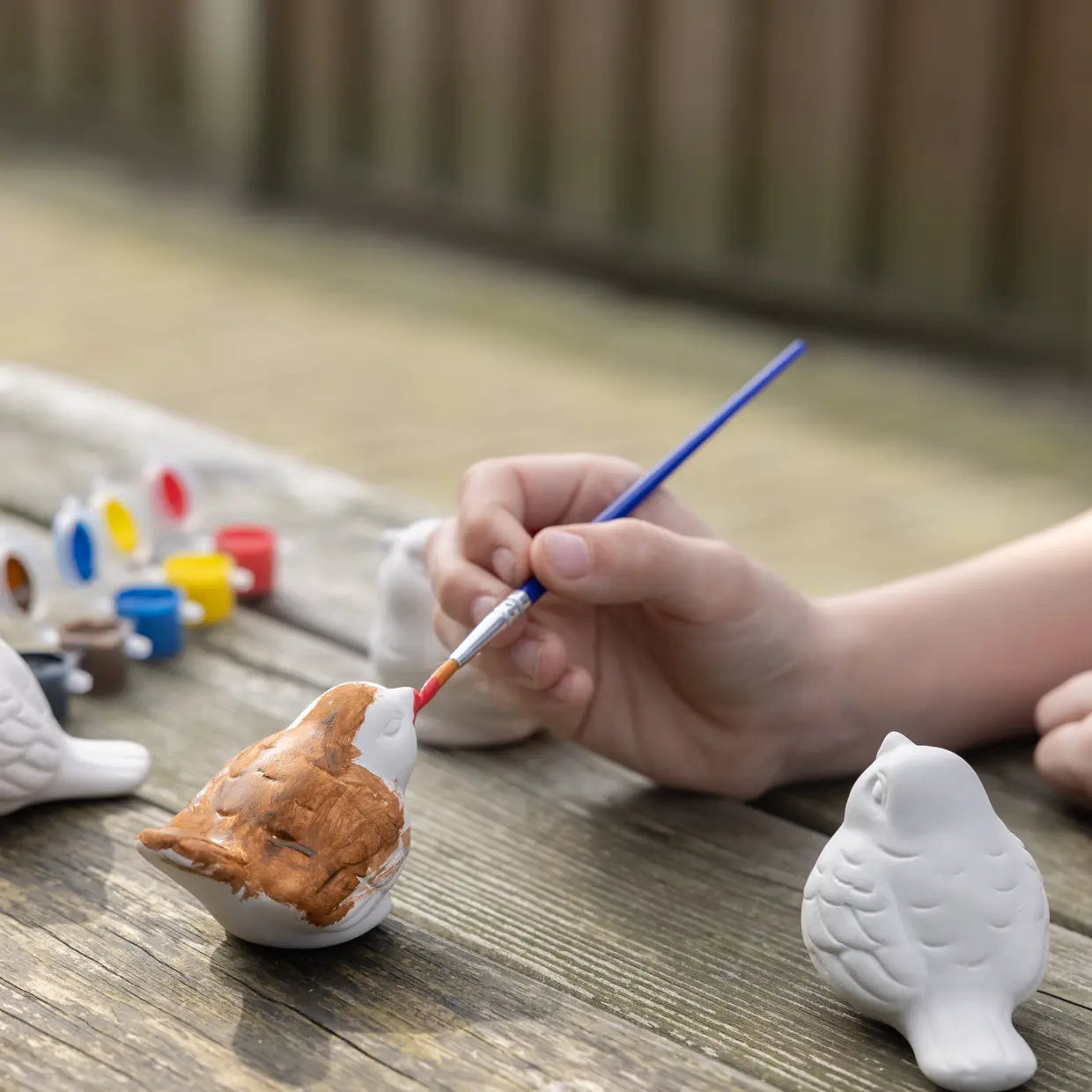 Kinderhand mit Pinsel, bemalt Vogel