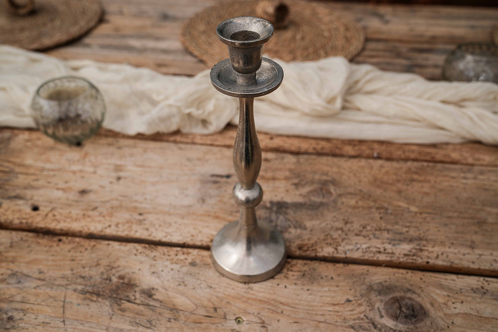 Kerzenständer in silber auf Holztisch.