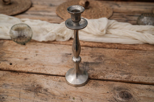 Kerzenständer in silber auf Holztisch.