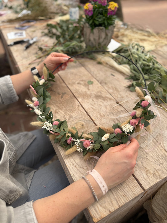 Frau hält Kranz aus Trockenblumen mit Metallring