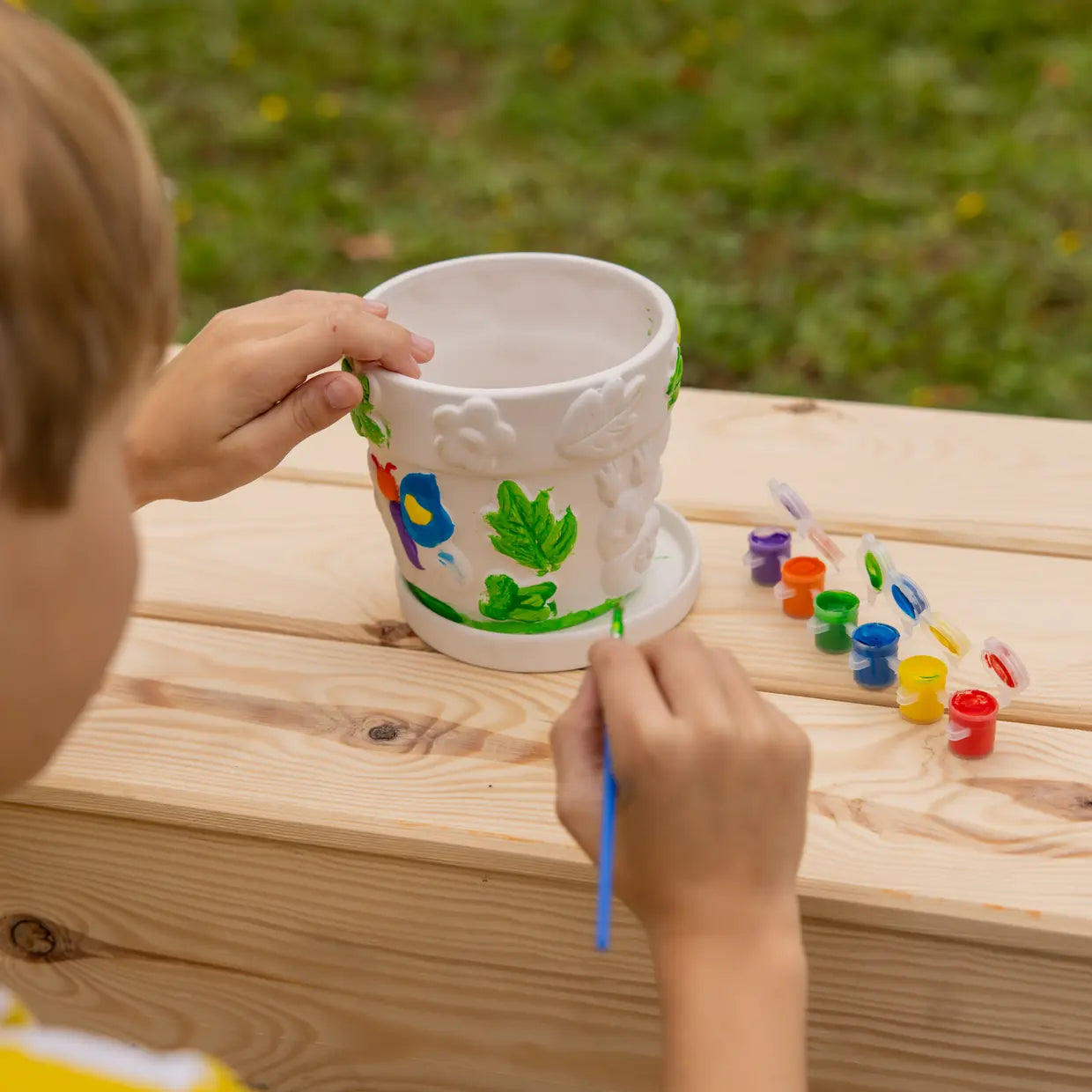 Kind bemalt Topf mit bunten Farben